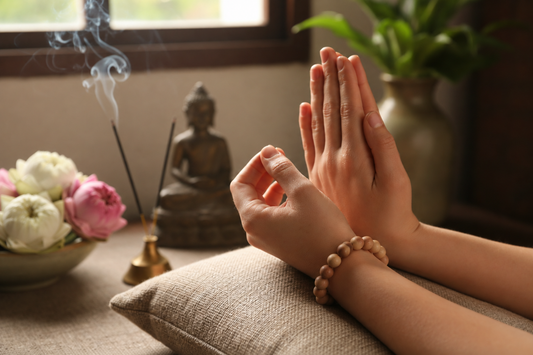 White Sandalwood bracelet worn on wrist during meditation with warm spiritual light