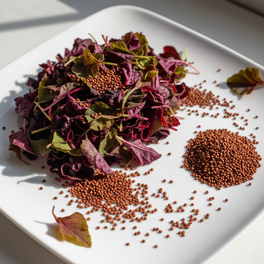 Fresh red amaranth chaulai leaves and seeds arranged on a clean white surface