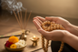 Polished Neem Japa Mala held in hands during meditation with warm golden light